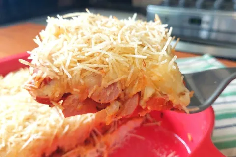 Cachorro quente de forno bem recheado e coberto com queijo d