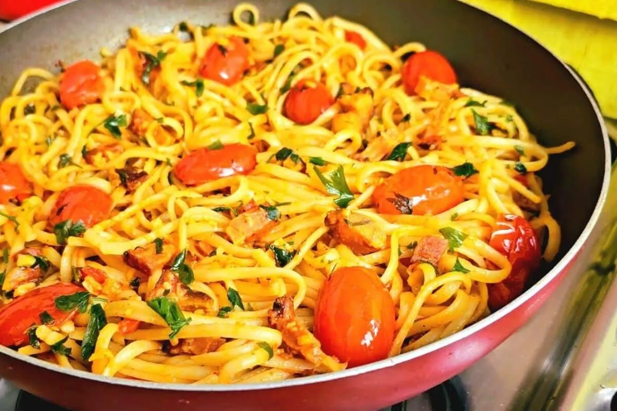 Macarrão ao alho e óleo com bacon e tomate, para uma refeiçã