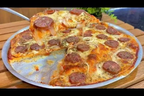 Pizza caseira de calabresa com bastante queijo derretido e u
